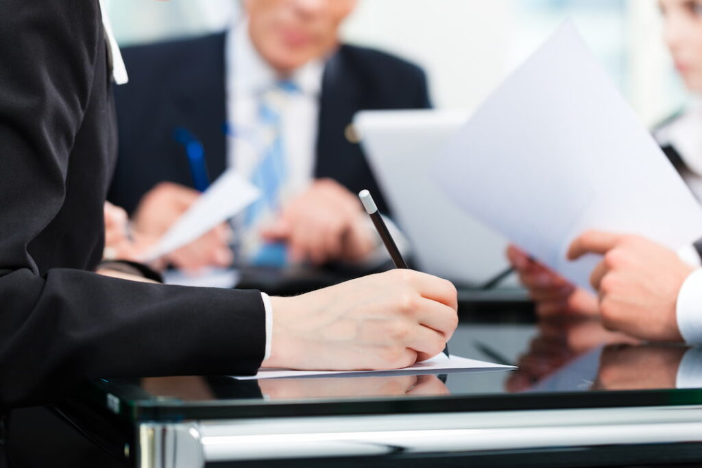 a person jots down notes during a business meeting