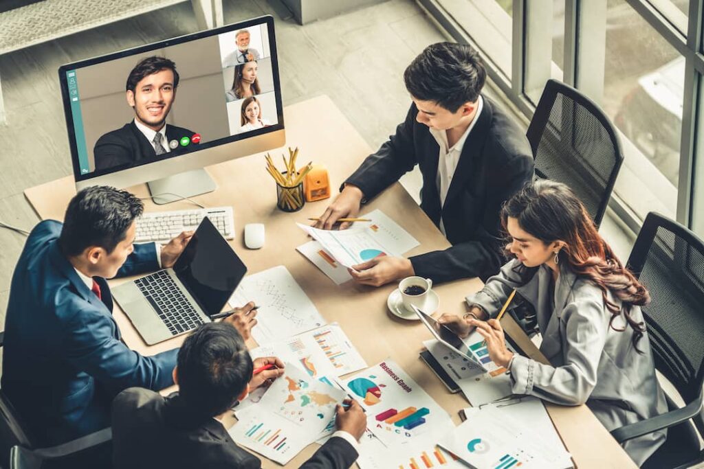 a focused team of employees meets around a conference table to review charts and graphs